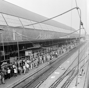 883126 Afbeelding van drukte op het derde perron van het N.S.-station Amsterdam C.S. te Amsterdam, met reizigers die ...